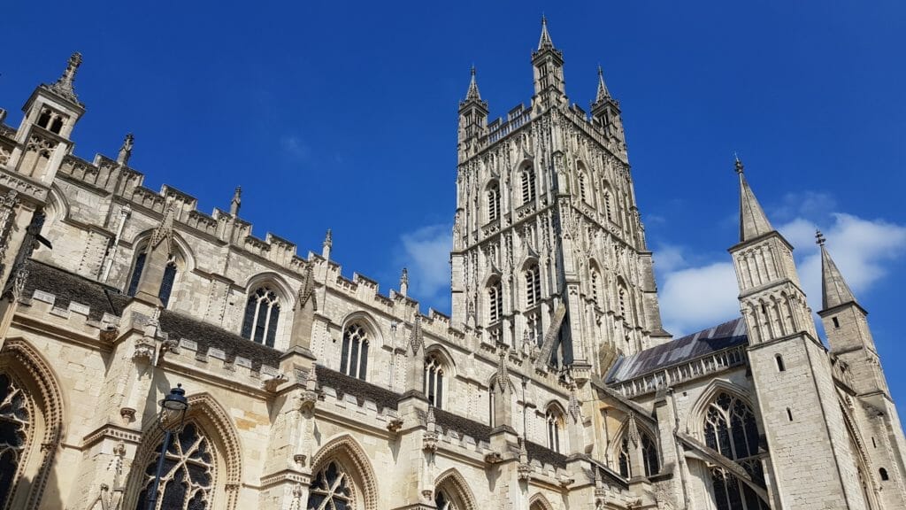 Close up photo of Bath Abbey, showing off the Abbey Tower against a blue sky.